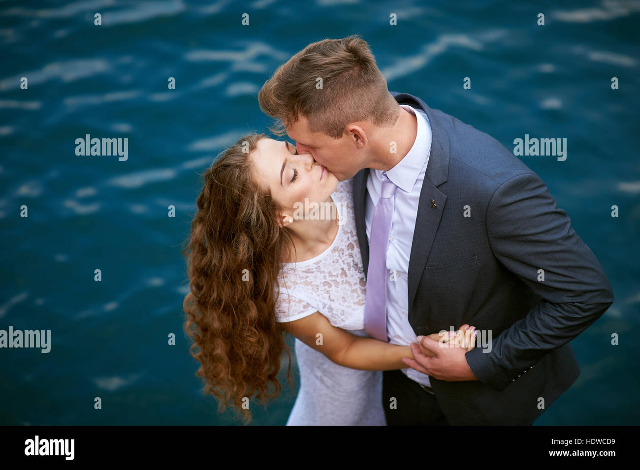 Bräutigam, die Braut küssen, auf dem Hintergrund des Wassers Stockfoto