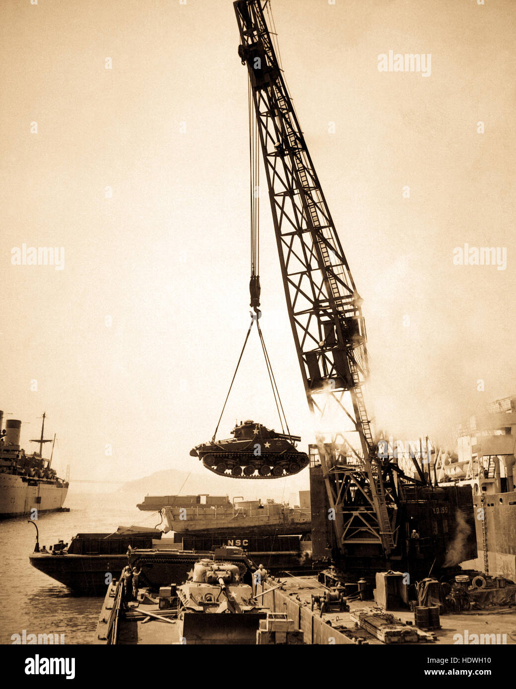 Marine Corps Panzer - bereit für die Front - werden an Bord einer Barke an der Naval-Versorgungsmaterial-Mitte per Kran für Umladen auf Kräfte im Pazifik Far Eastern Befehl geschwungen. Stockfoto