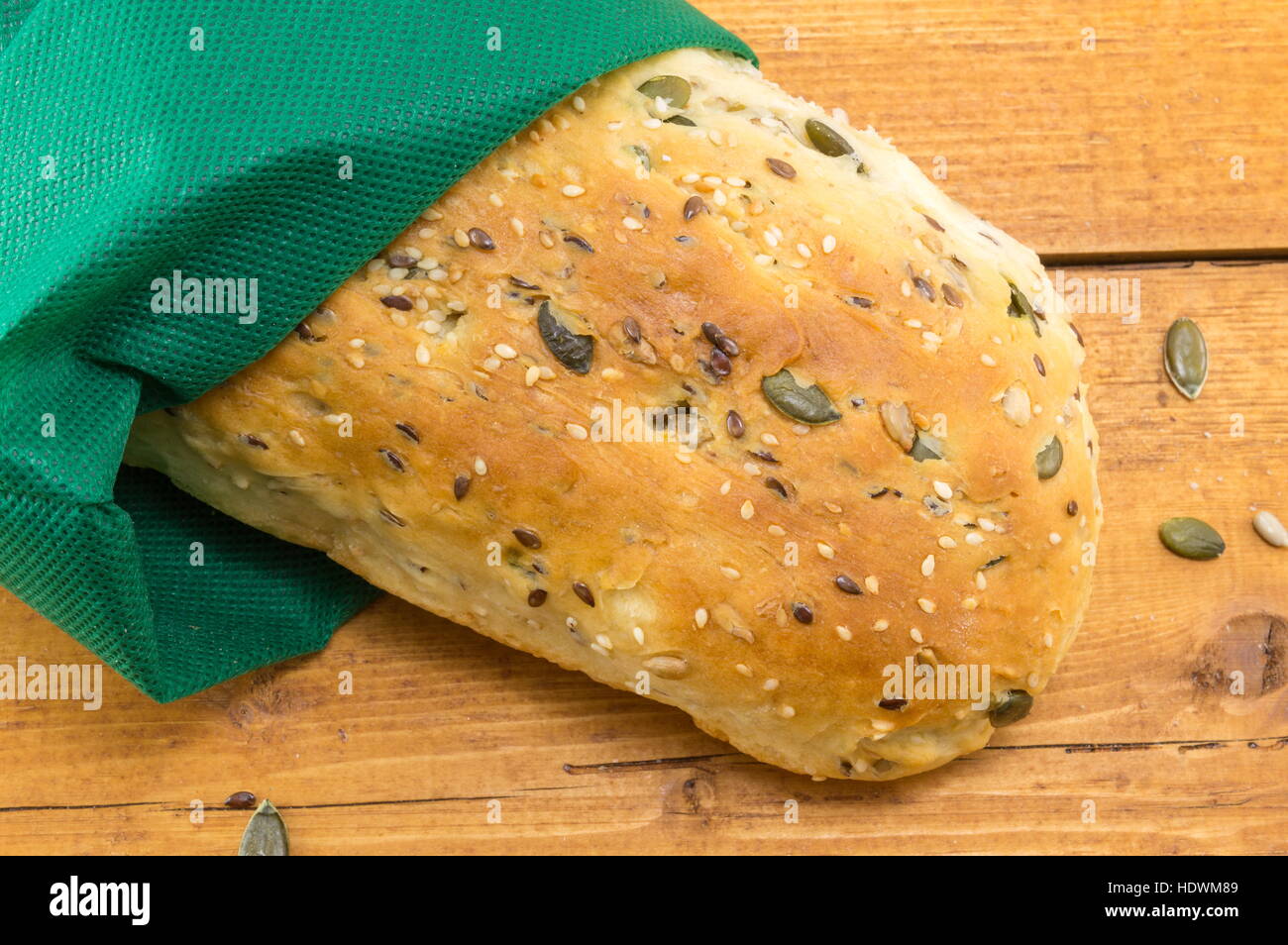 selbstgebackenes Brot mit Samen auf einem Holztisch Stockfoto