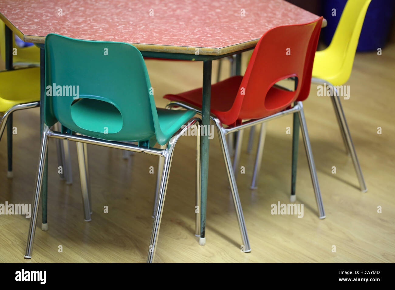 bunte Stühle um den Tisch im Klassenzimmer eines Kindergartens Stockfoto