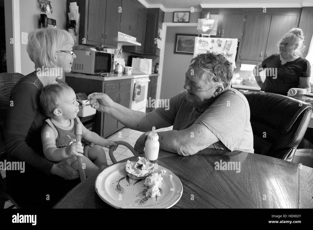 Kaukasische Großvater Fütterung Enkel in Küche Stockfoto