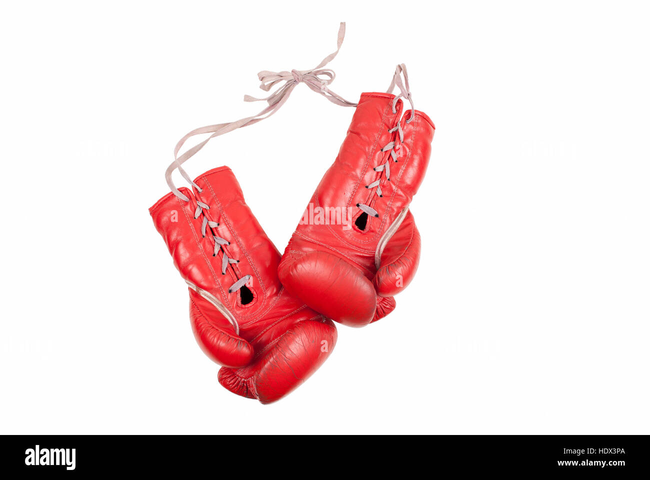 alten verwendet und zerschlagen rotem Leder Boxhandschuhe mit Schnürsenkeln isoliert auf weißem Hintergrund Stockfoto