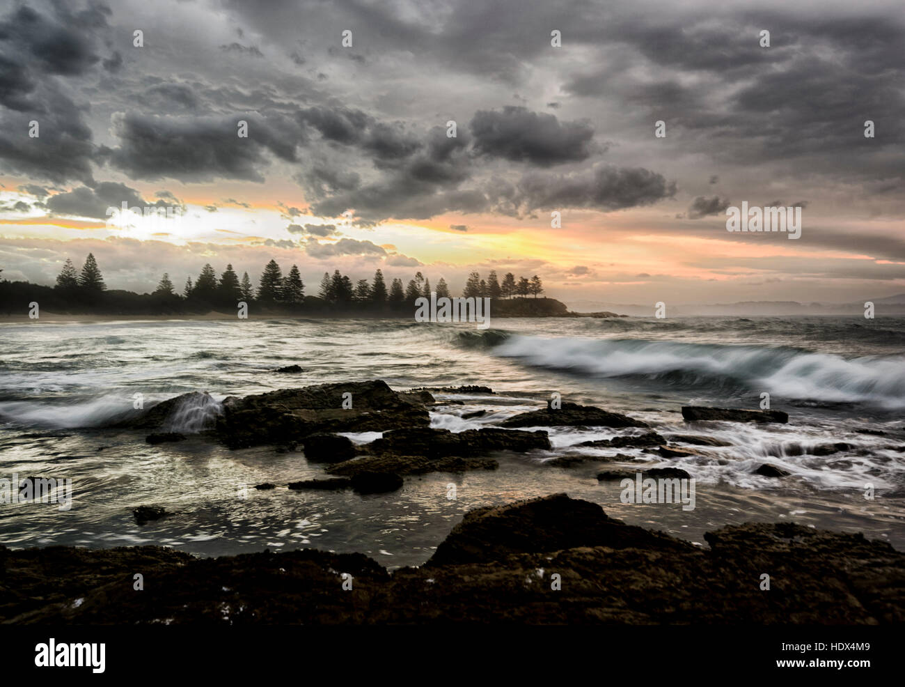 Dramatische stimmungsvollen Sonnenuntergang über große Wellen am Strand von Bermagui, South Coast, New South Wales, NSW, Australien Stockfoto