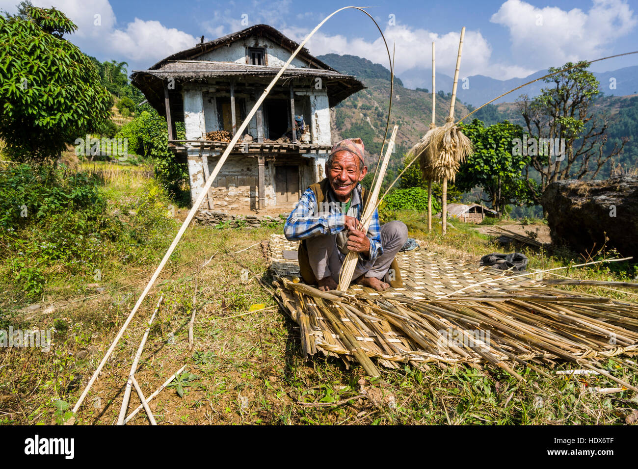 Ein Mann ist Flechten ein Bambus Wand vor seine Bauern Haus Stockfotografie  - Alamy
