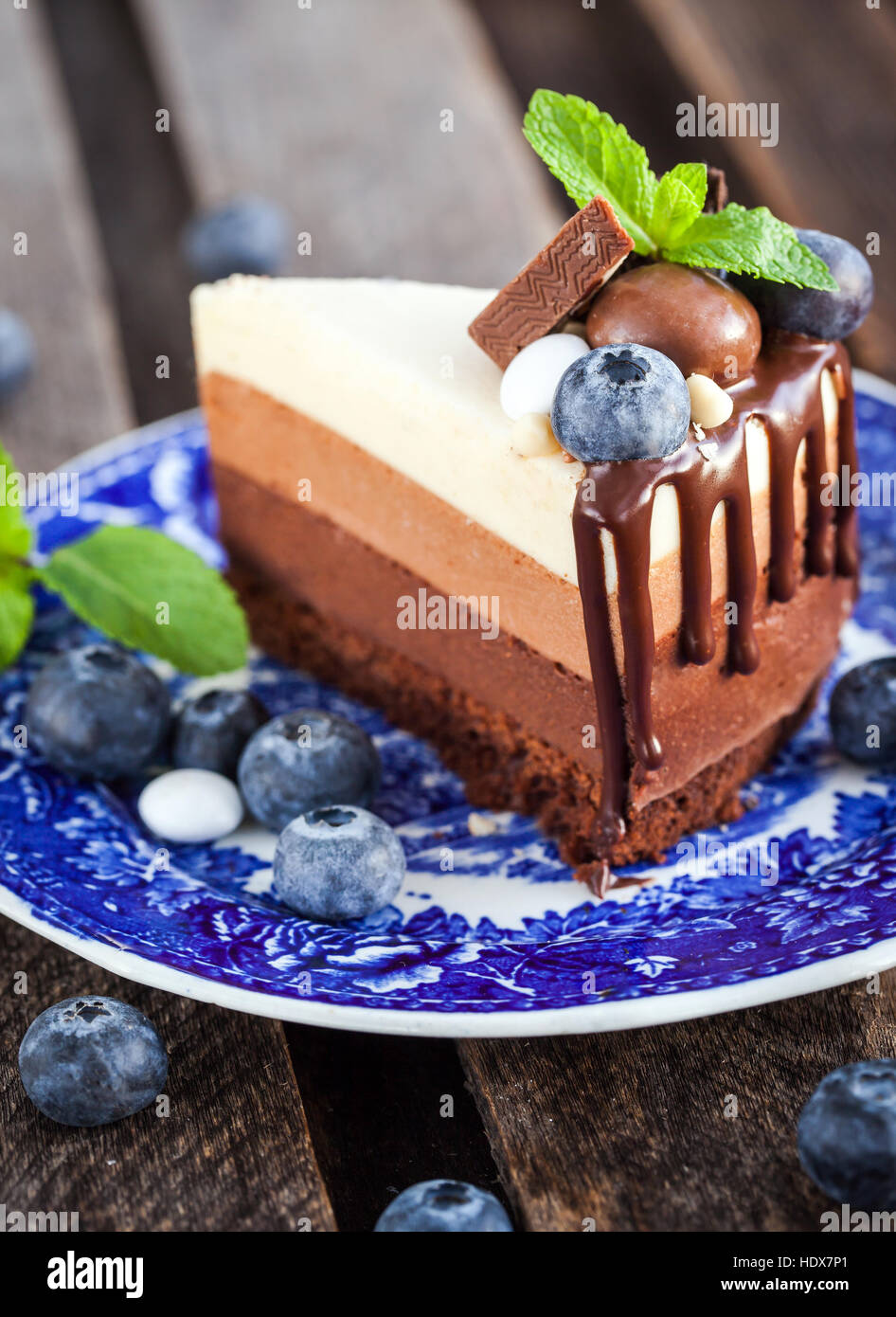 Köstlichen drei Mousse au Chocolat Torte dekoriert mit frischen Heidelbeeren, Minze und Bonbons Stockfoto