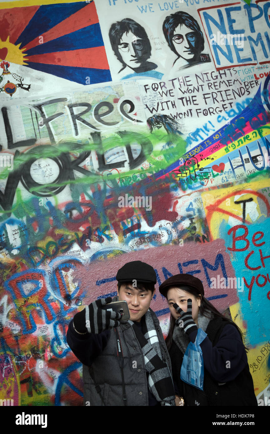 Zwei Besucher posieren für ein Selfie vor der John-Lennon-Mauer in Malá Strana, Prag Stockfoto