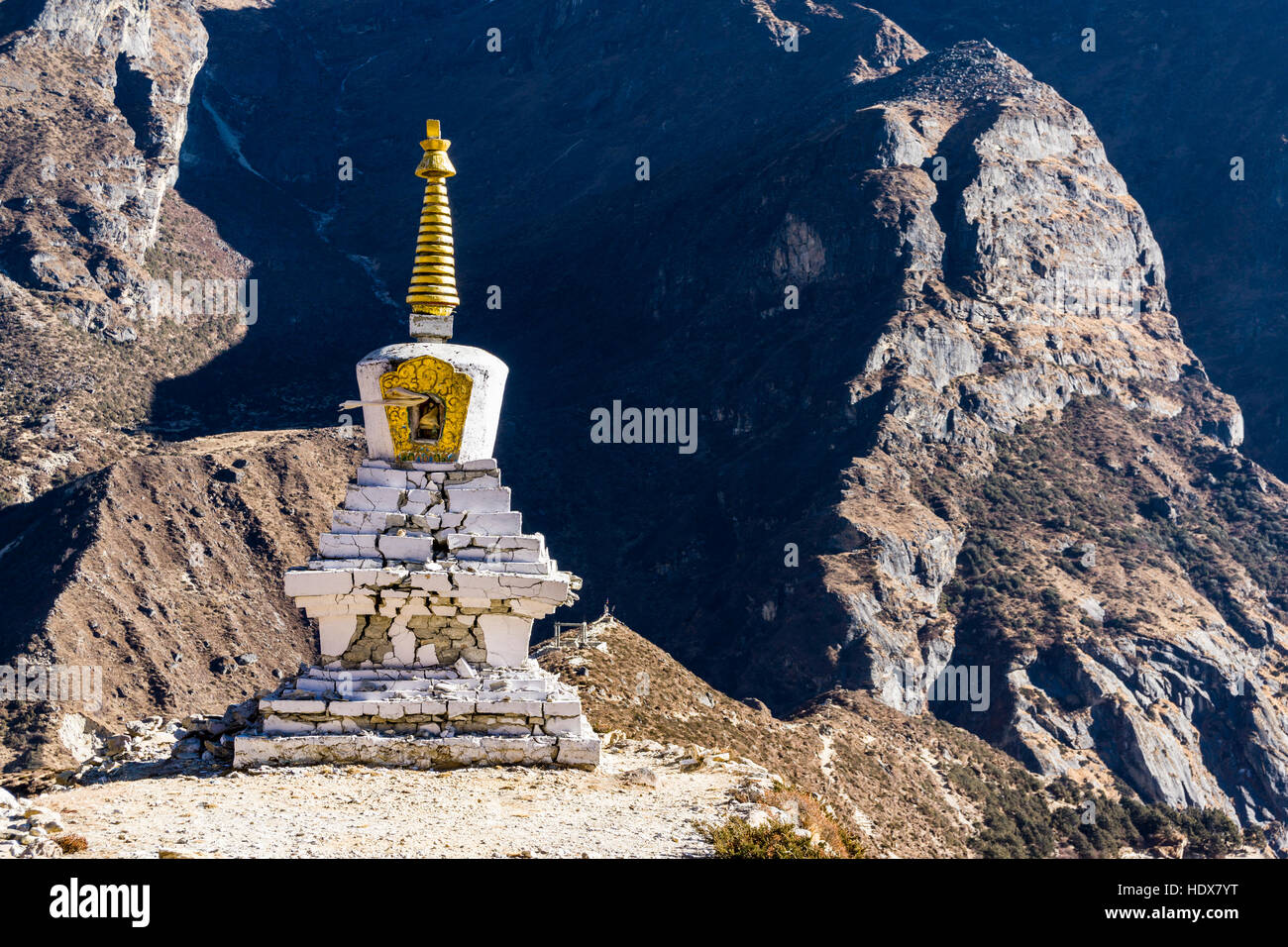 Eine während des Erdbebens 2015 beschädigte weiße Stupa am Eingang des Dorfes Stockfoto