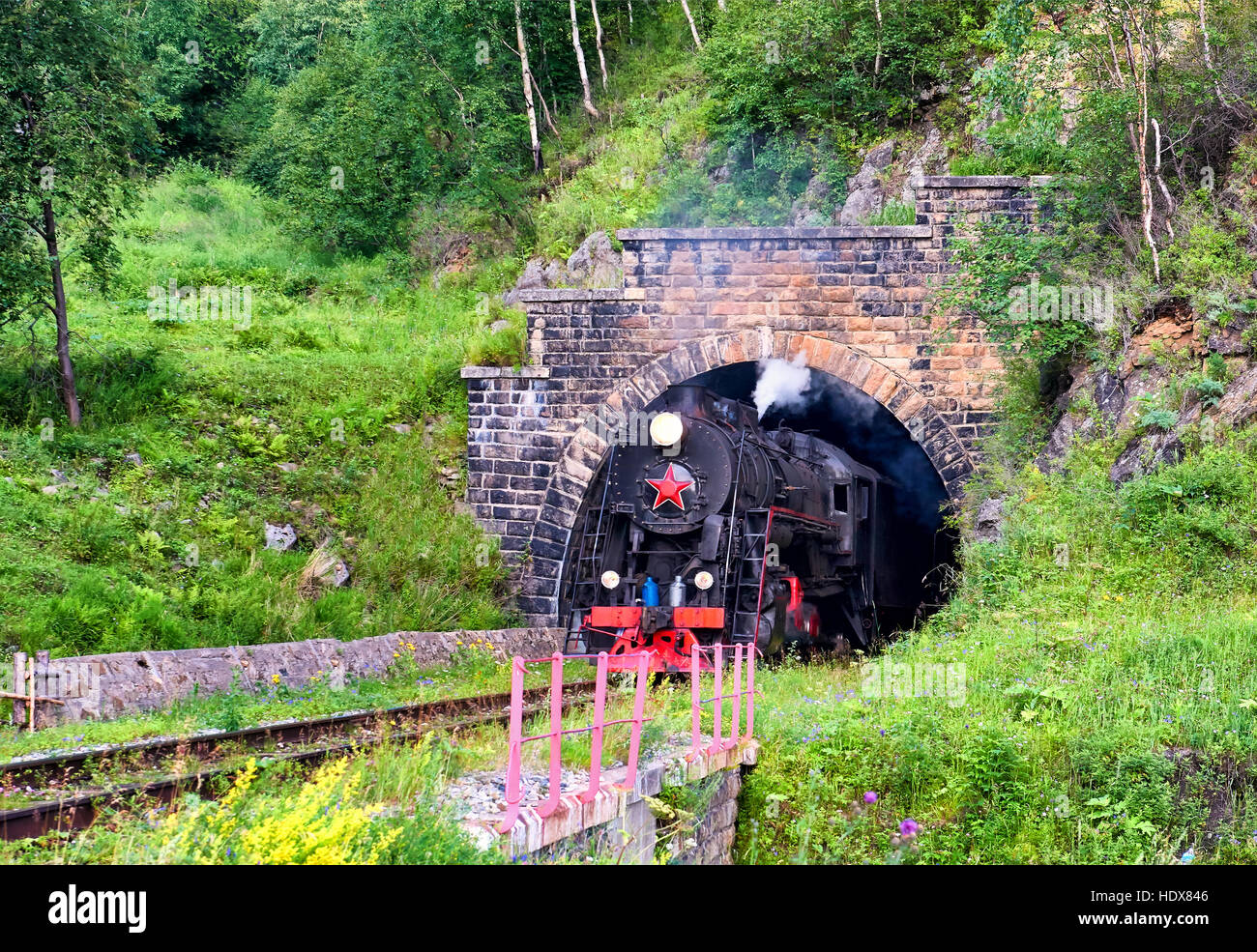 Vintage Dampfzug fährt vom Bogen der Eisenbahntunnel. Circum-Baikal-Bahn. (geringe Schärfentiefe Schärfe) Stockfoto