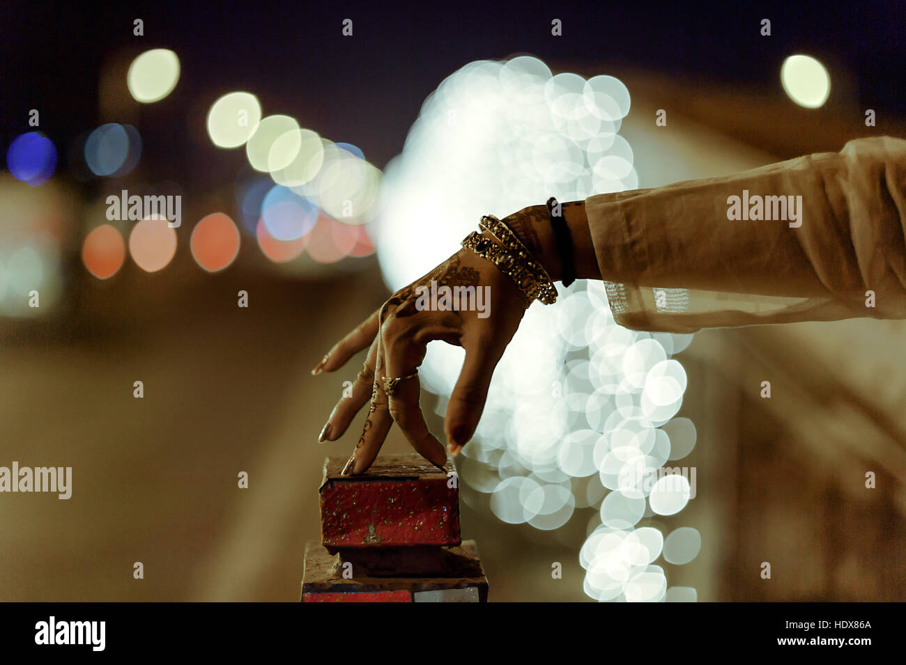 Eine Hand der Indianerin mit Henna und Ornamente mit bunten Bokeh im Hintergrund Unschärfe in der Nacht Stockfoto