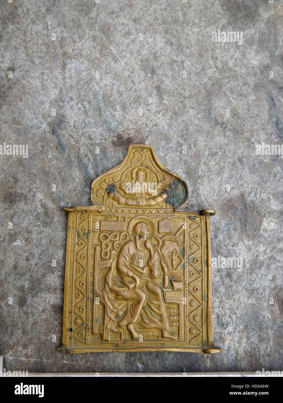 Vintage alte Metall Bronze, Kupfer orthodoxe Ikone Skapulier mit grüner Patina auf einem alten Stein Hintergrund bedeckt. Stockfoto