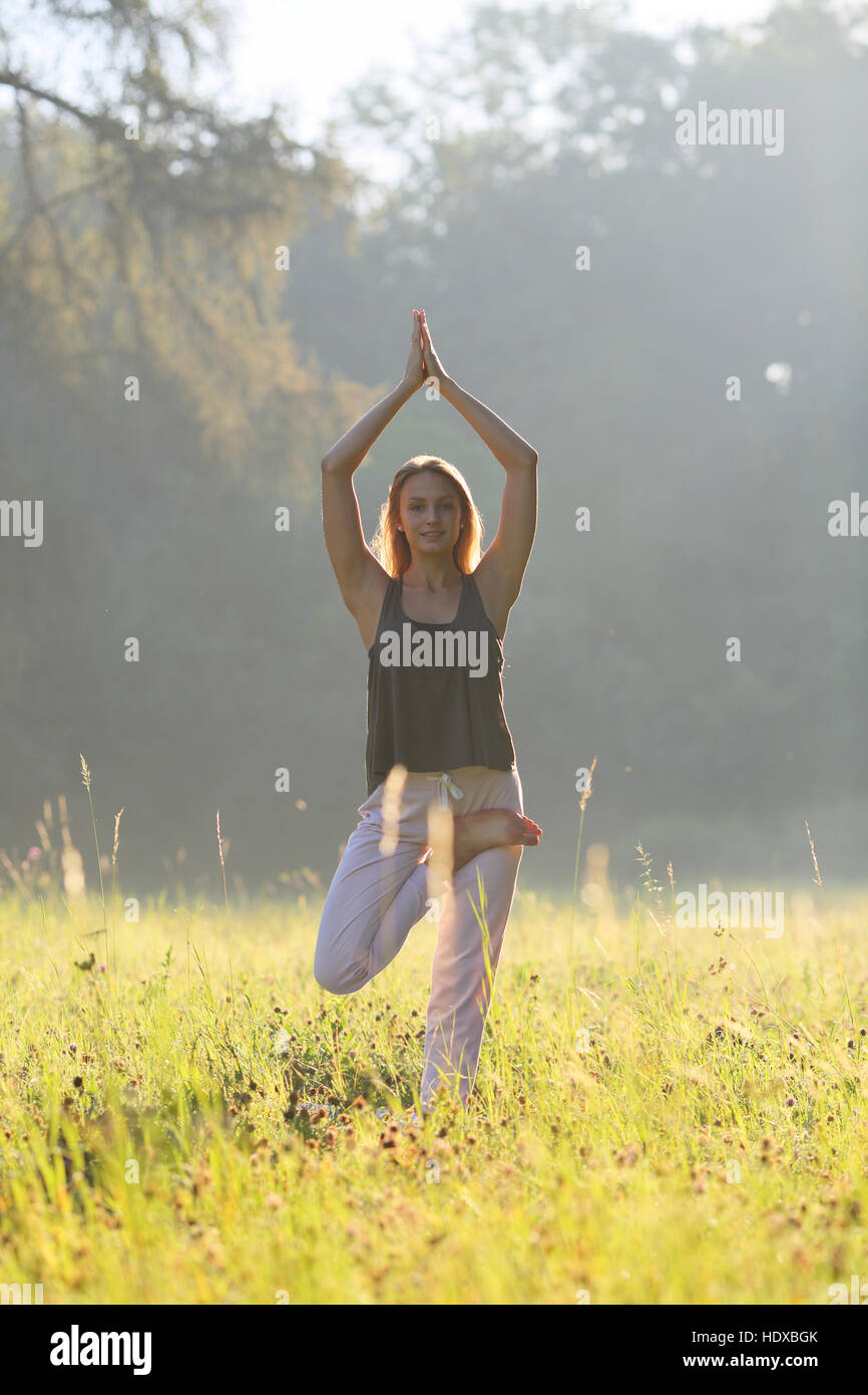 Frau Smilling auf Meditation mit Händen an der Spitze Stockfoto