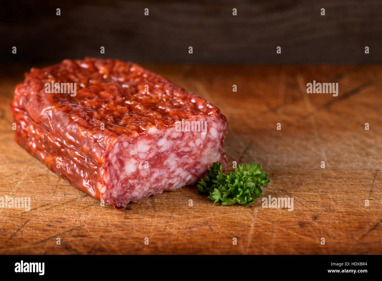 Frische italienische Salami auf Holzbrett mit Petersilie Stockfoto