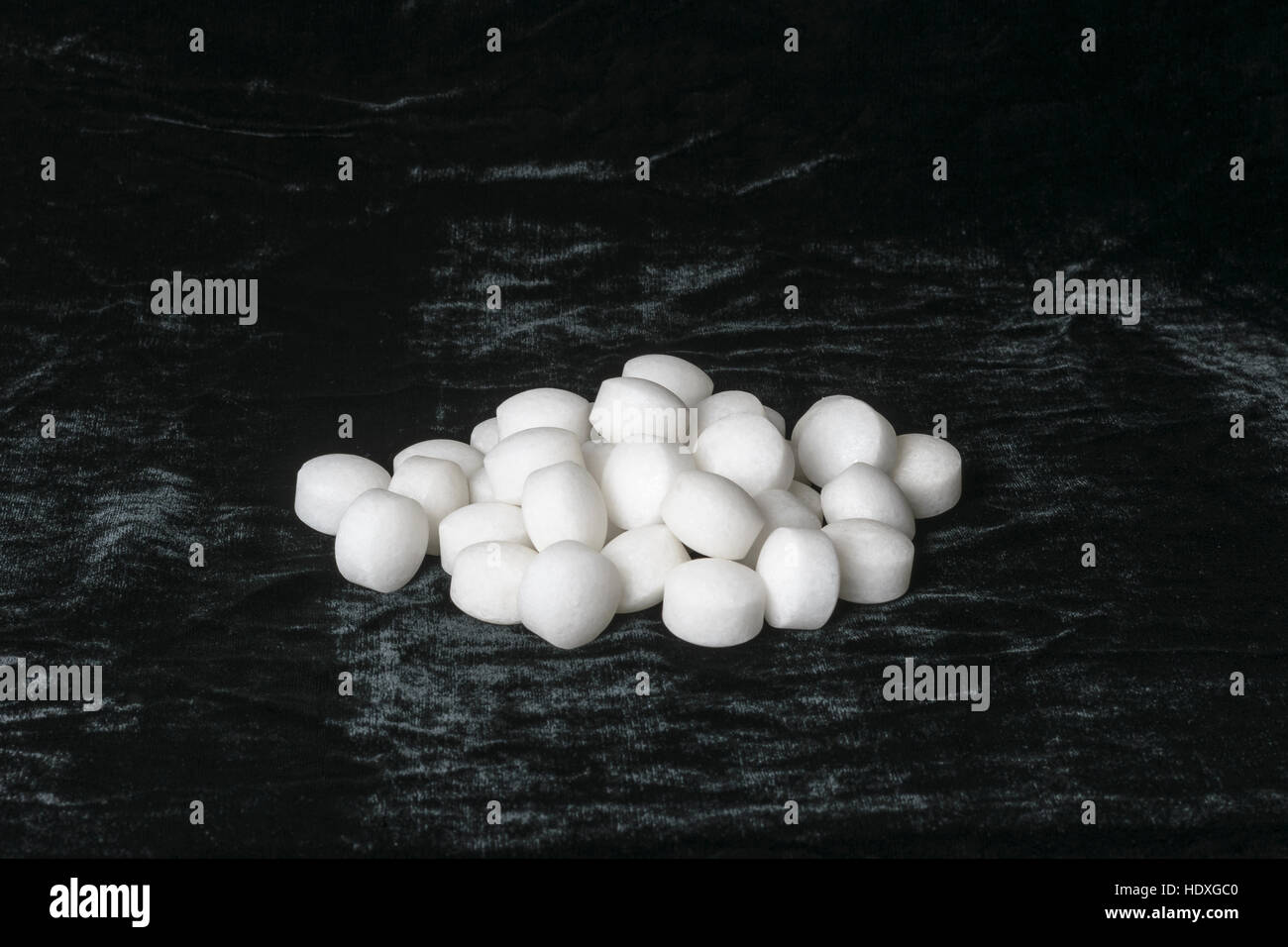 Weiße Naphthalin Kugeln auf schwarzem Samt Stockfoto