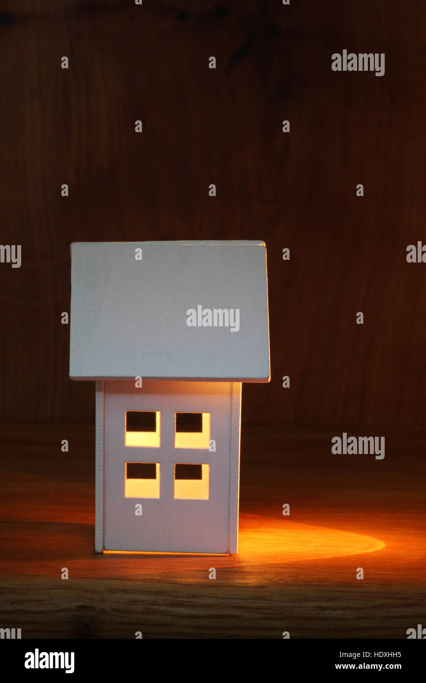 Modell Holzhaus mit Licht, das auf der einen Seite für Effekt gemalt. Konzept des neuen Heims mit Platz für Text. Stockfoto