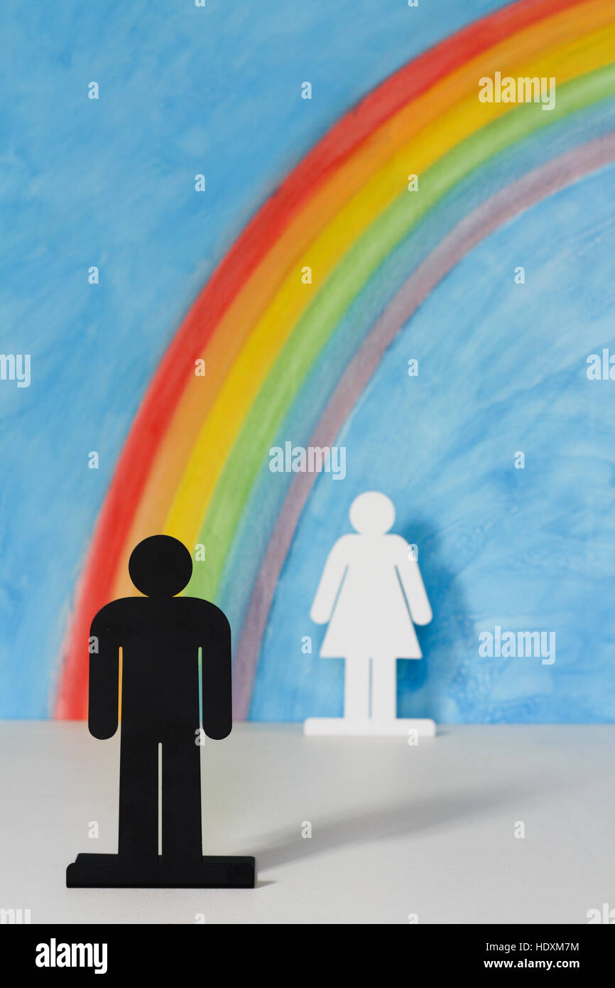 Mann und Frau Symbole mit einem Regenbogen und blauer Himmel zur Veranschaulichung des Konzepts der Gleichstellung der Geschlechter und Diskriminierung; der Mensch im Vordergrund. Stockfoto