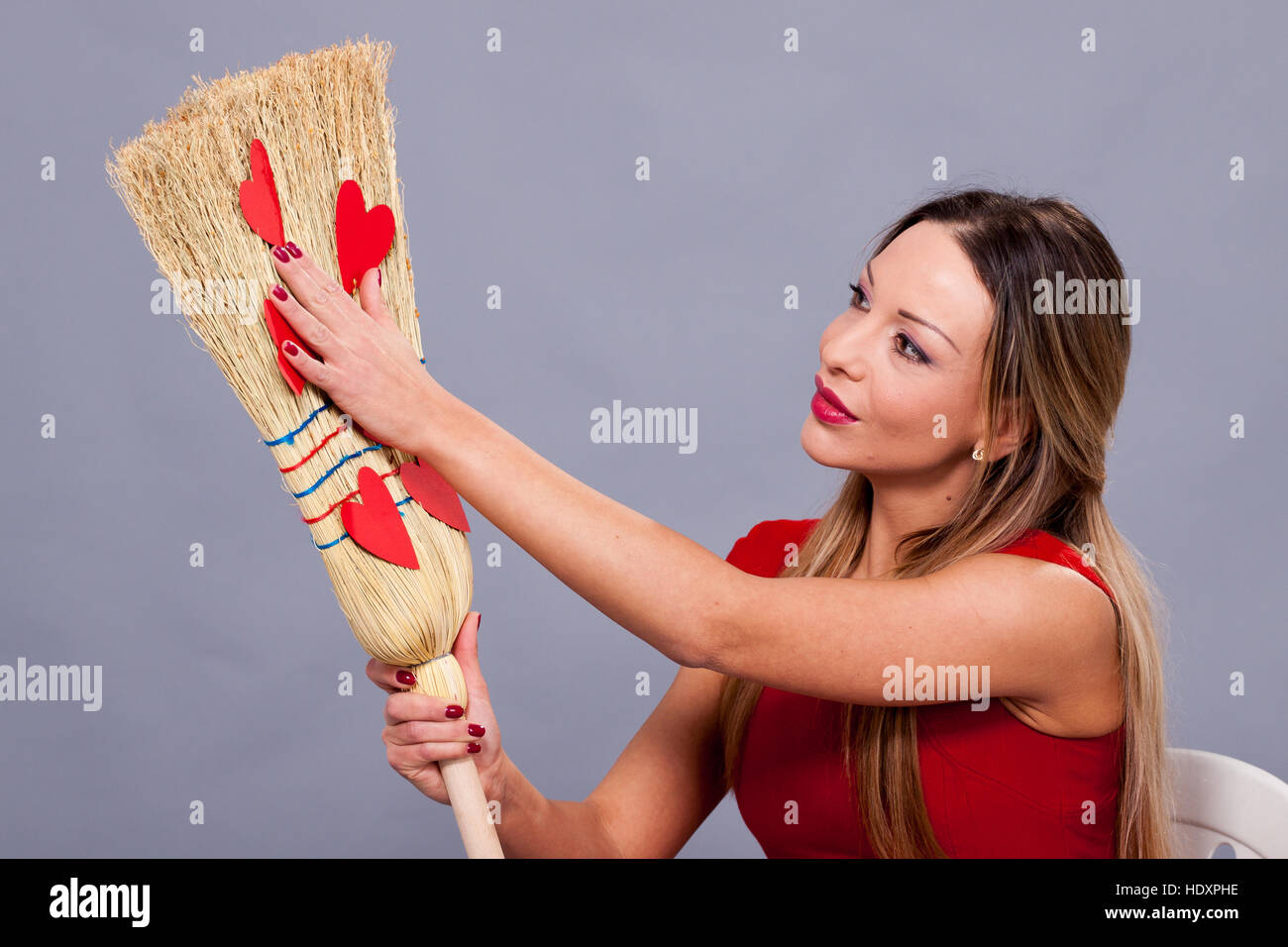 Urlaub Valentinstag, schöne Frau posiert mit roten Herz aus Papier auf den Besen Stockfoto