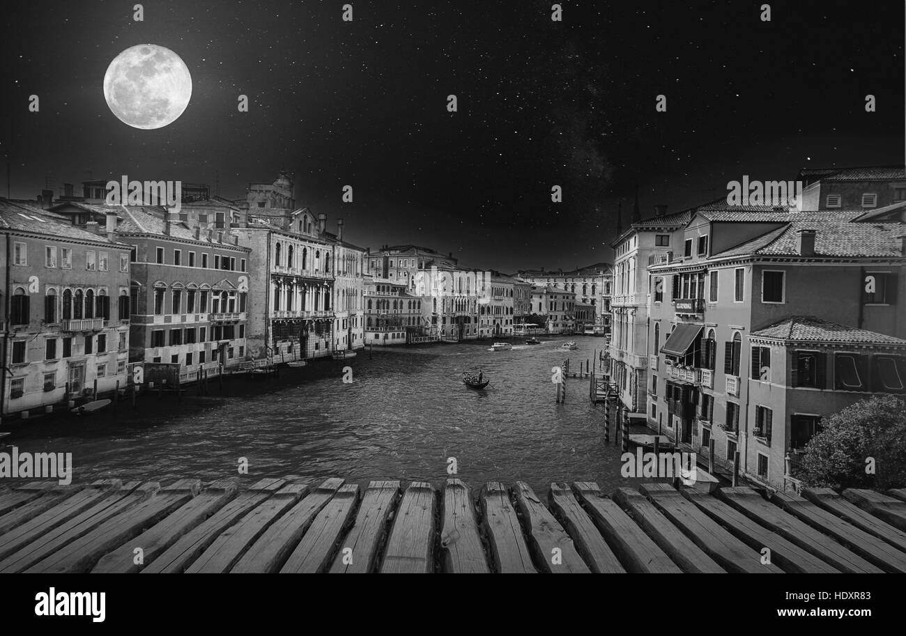 Fine Art Retro-Bild mit Gondel am Canal Grande in der Nacht mit Holzbohlen Boden für Vordergrund, Vollmond und milchig, Venedig, Stockfoto