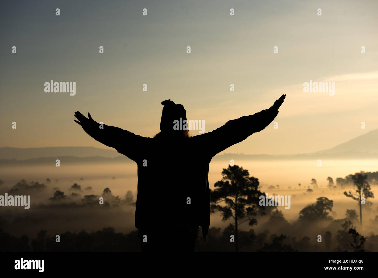 Silhouette touristischen Frau hob die Hand zum Sonnenaufgang und fühle mich glücklich Stockfoto