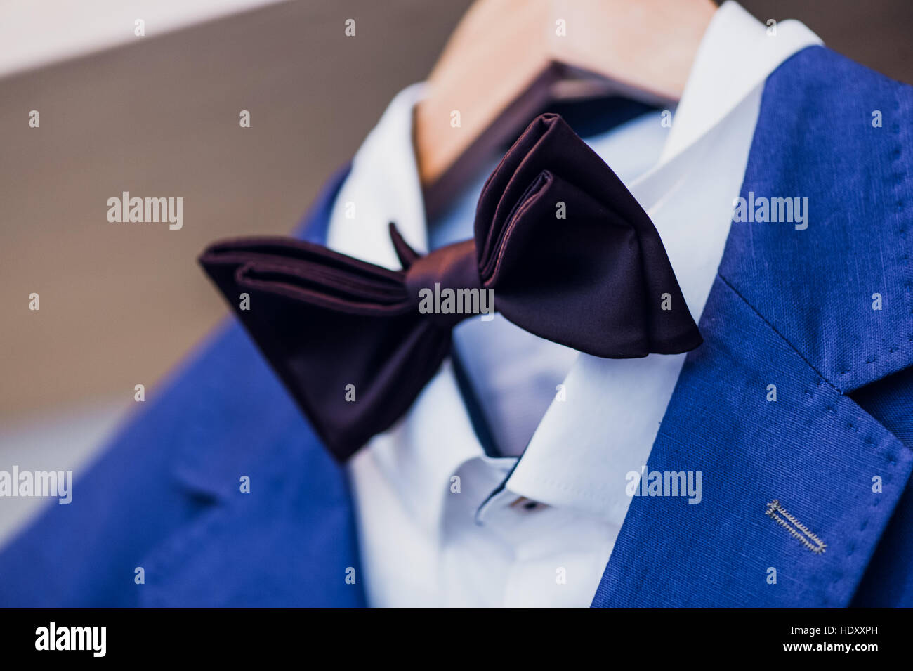 Nahaufnahme der blaue Jacke mit Fliege auf einem Kleiderbügel. Stockfoto