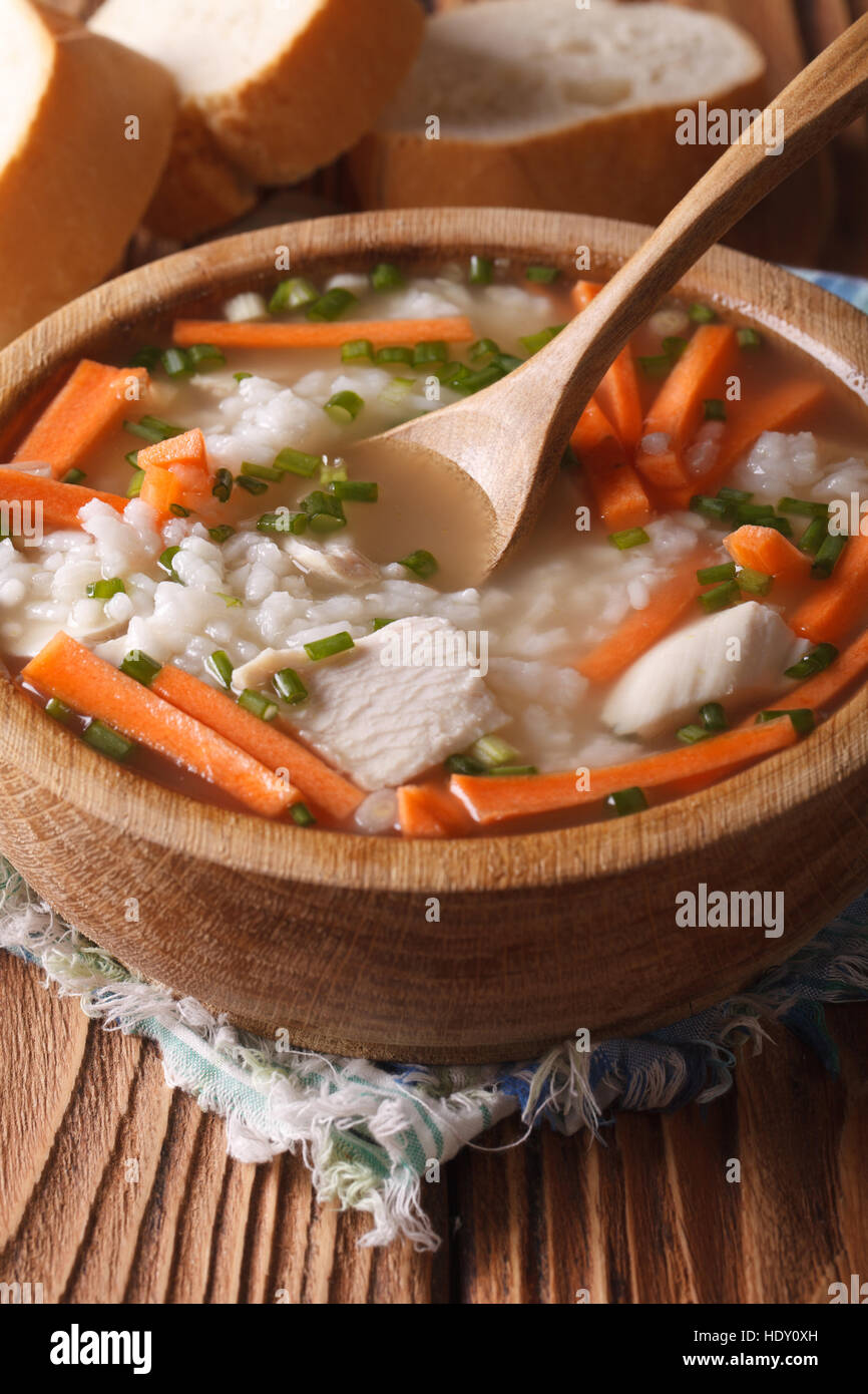 Huhn-Reis-Suppe hautnah in einer Holzschale. Vertikale, rustikalen Stil Stockfoto