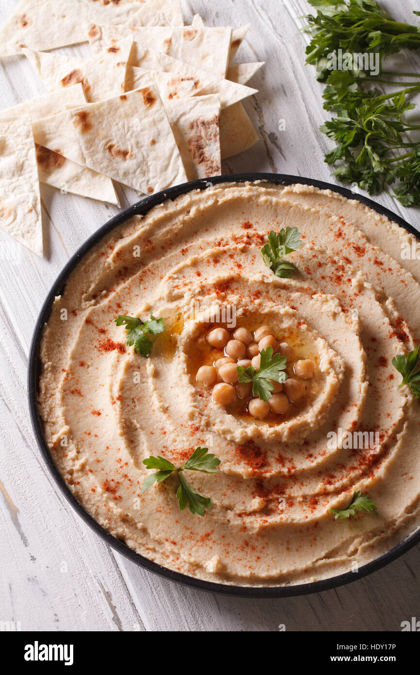 Köstliche Hummus mit Paprika und Petersilie auf den Teller Closeup. vertikale Stockfoto