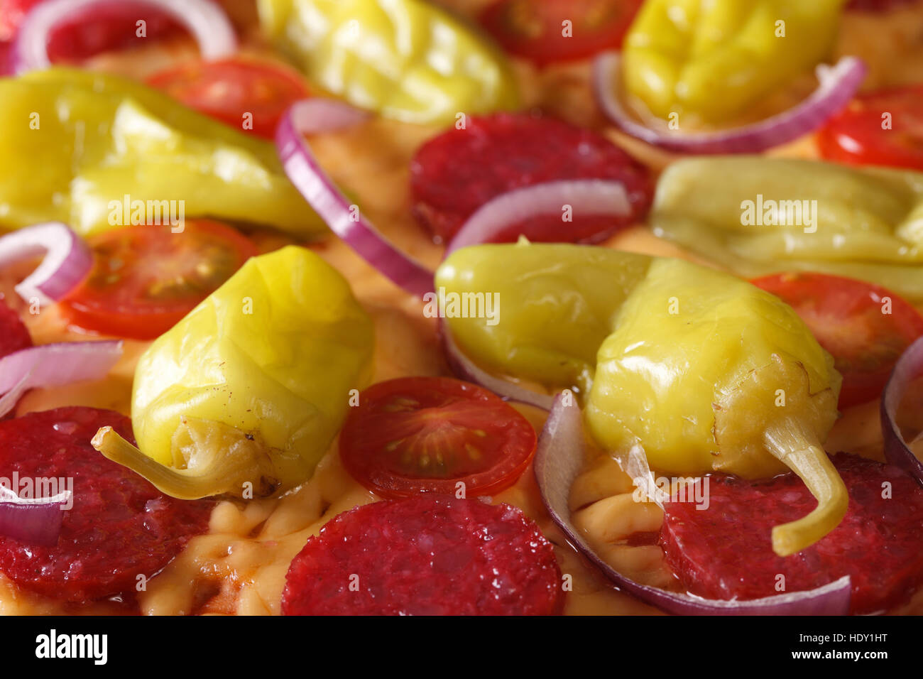 Pizza mit Salami, Peperoni, Paprika und Tomaten Makro horizontale Stockfoto