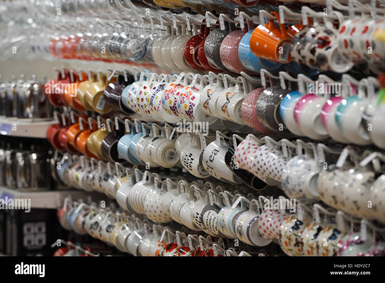 Hunderte von Tassen hängen an ihren Griffen in einem Geschäft. Stockfoto