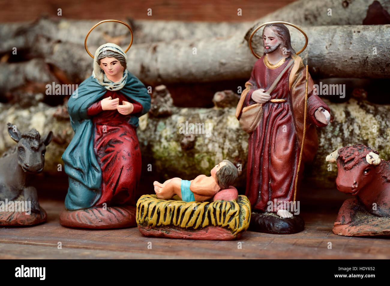 die Heilige Familie, das Jesuskind, der Jungfrau Maria und St. Joseph, und der Esel und Ochsen in eine rustikale Weihnachtskrippe Stockfoto