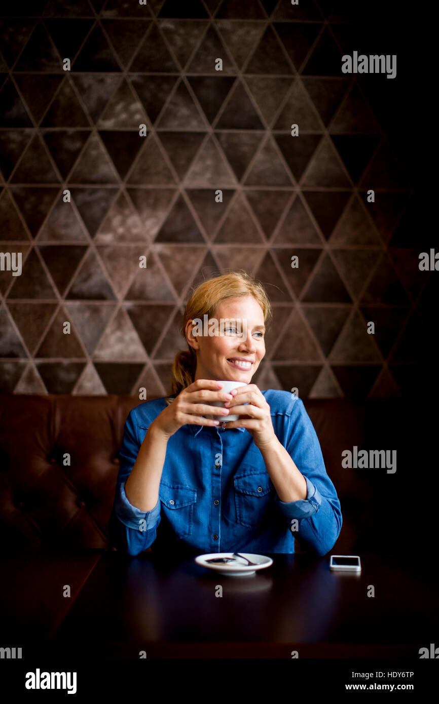 Frau, trinken eine Tasse Kaffee im Café und auf der Suche nach glücklich Stockfoto