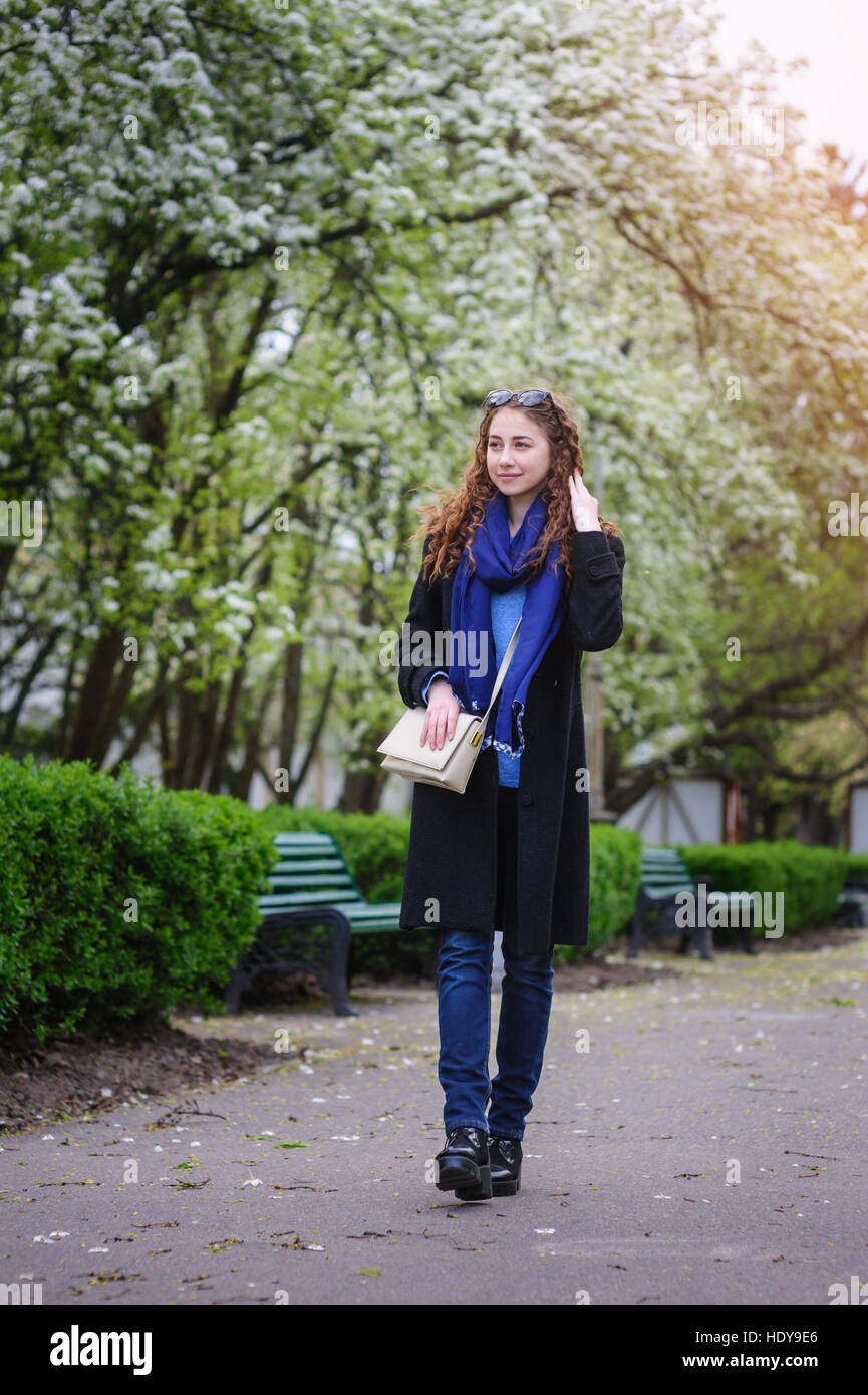 schöne junge Frau, die zu Fuß auf Frühling Park Stockfoto