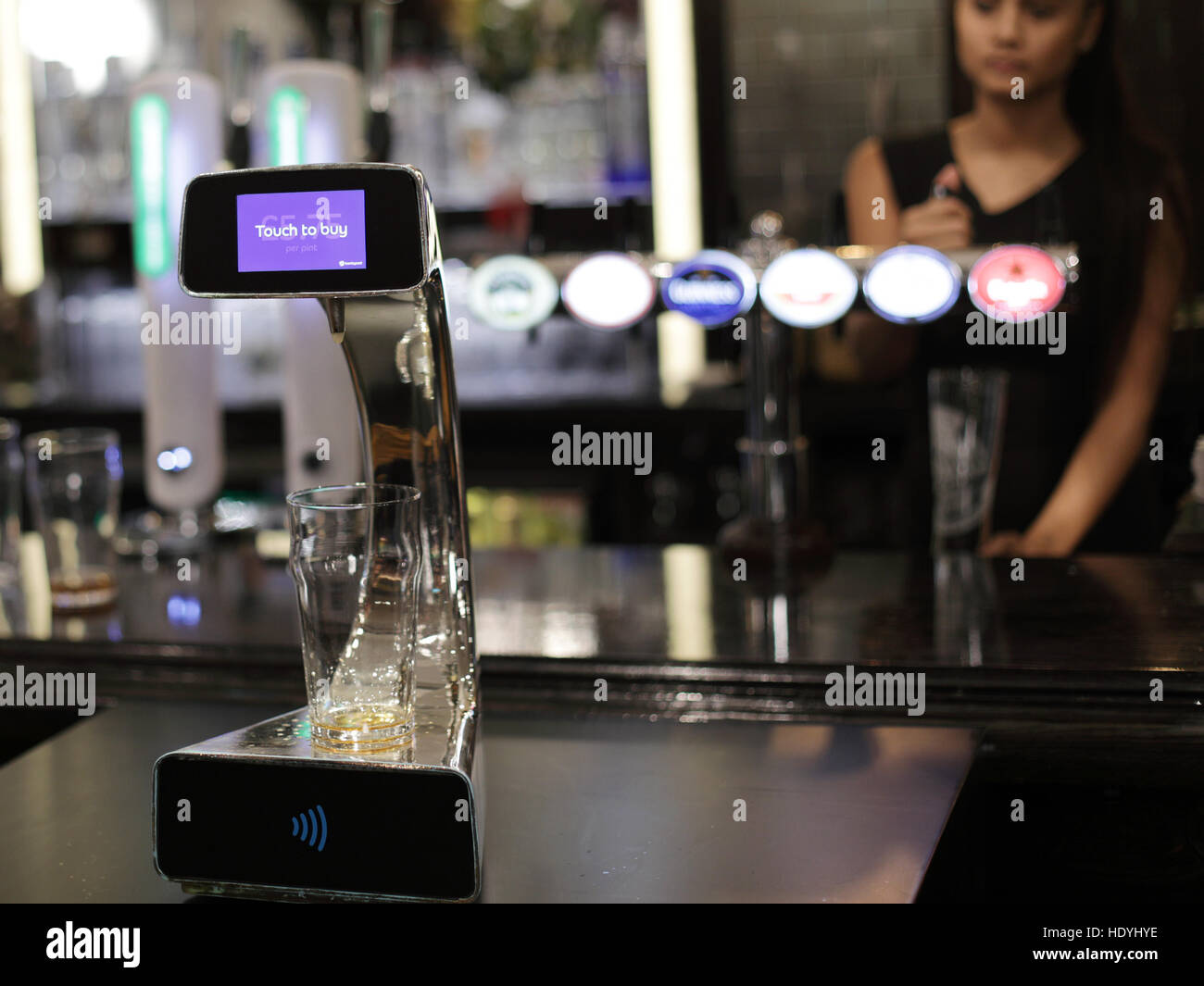 Im Henry's Cafe and Bar in Piccadilly, London, findet eine Demonstration der weltweit ersten kontaktlosen, selbstbedienenden Bierpumpe statt, die von Barclaycard entwickelt wurde, um die Warteschlangen an Bars abends zu verringern. Stockfoto