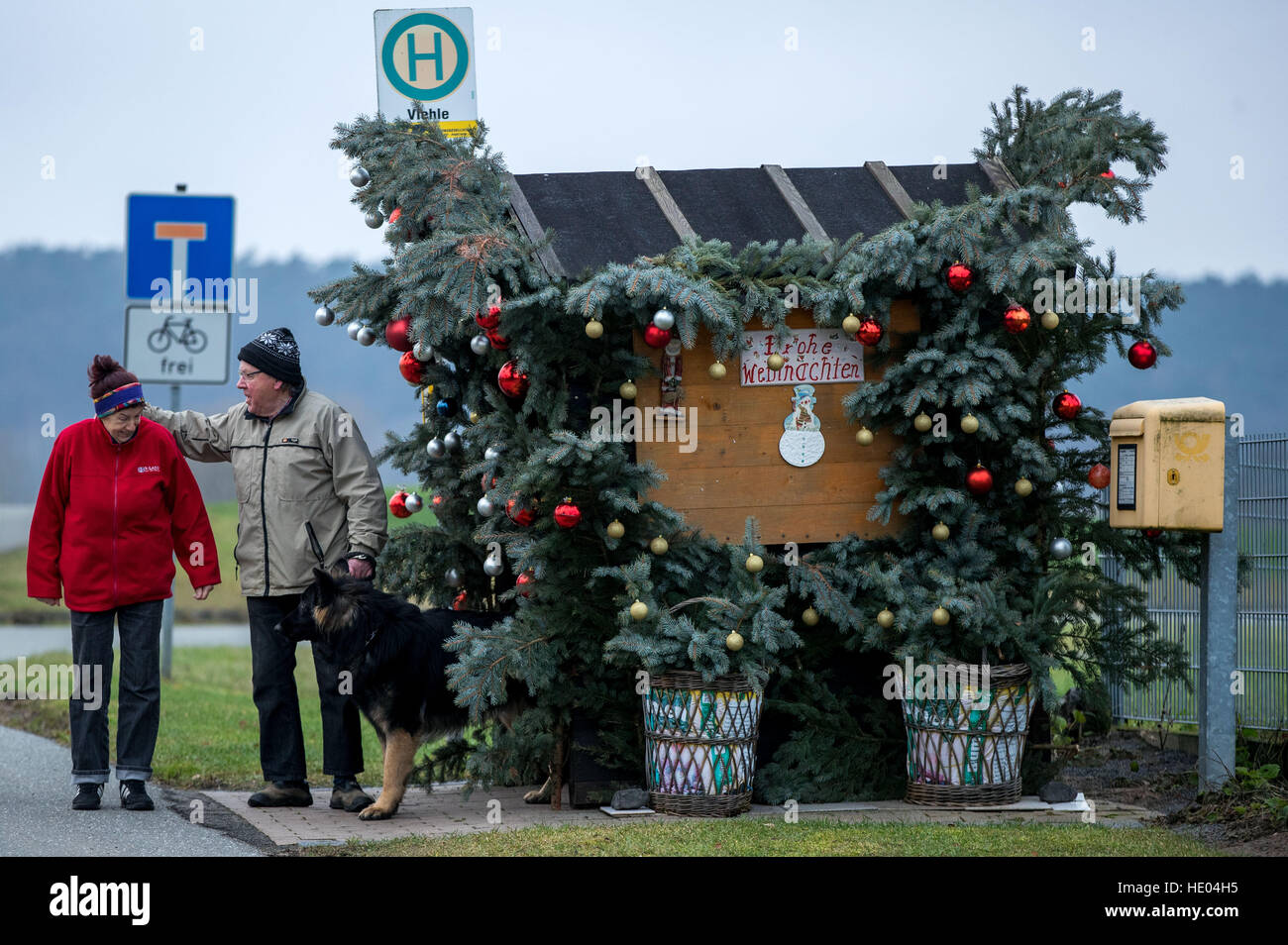 Wernfried und Adelheid Meyer stehen neben den verzierten die Bushaltestelle in ihrem Dorf befindet sich in der Nähe der Elbe mit 24 Einwohnern, Viehle, Deutschland, 15. Dezember 2016. Seit Jahrzehnten hat der 72-j hrige das kleine Holzhaus mit Zweige Grün und bis zu 300 Glitzer Kugeln dekoriert. Der Bus kommt nur während der Woche, ein Kind für die Schule zu holen. Eingerichteten Bushaltestelle ist an den Adventswochenenden ein beliebtes Ausflugsziel geworden. Foto: Jens Büttner/Dpa-Zentralbild/dpa Stockfoto