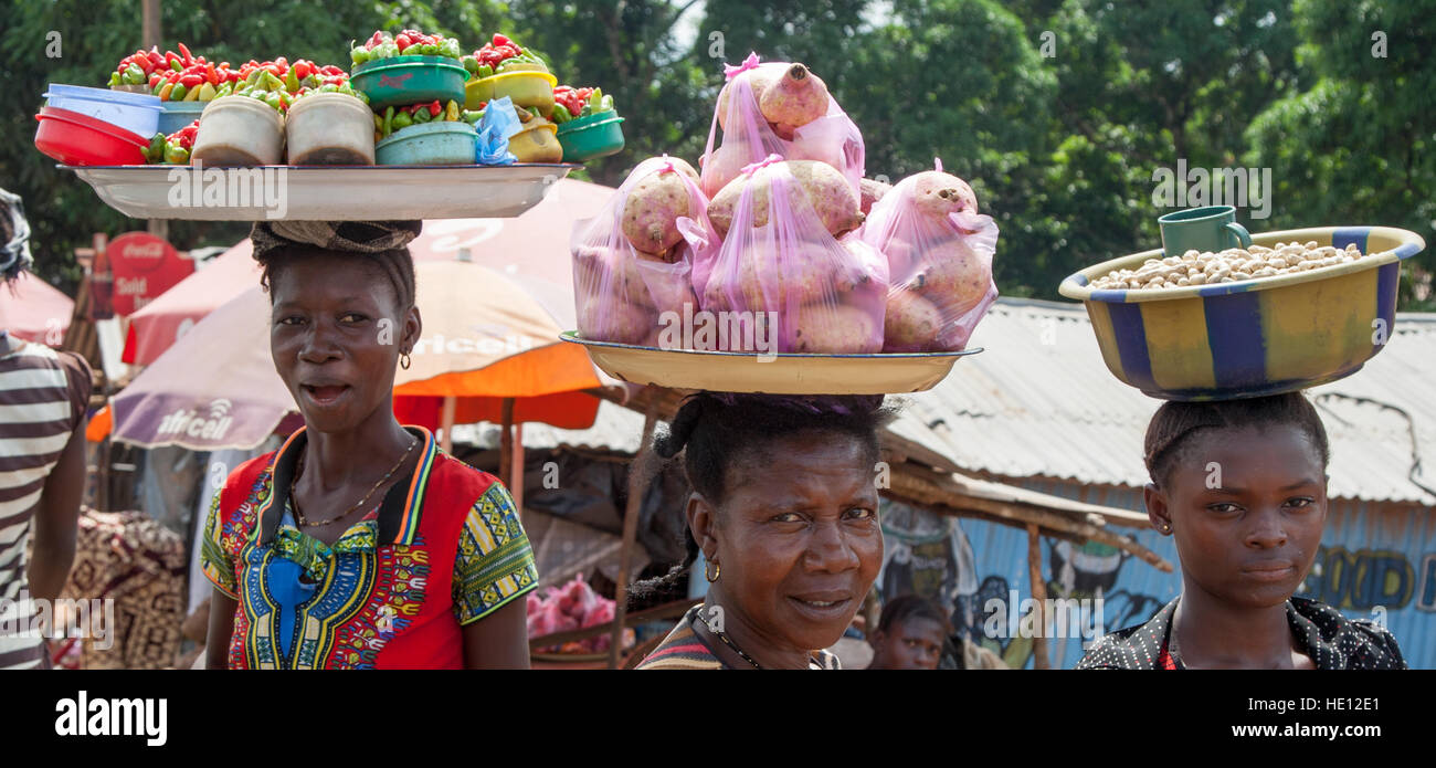 Afrikanische Menschen, die die Körbe von Lebensmitteln auf den Kopf Stockfoto