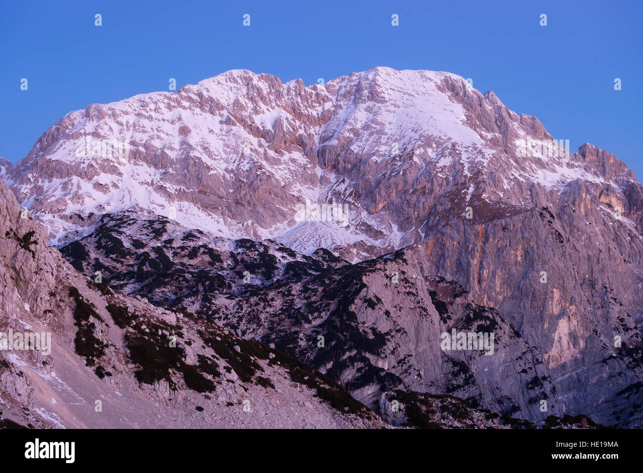 Gipfel des Mt. Rjavina (2532 m ü.d.m.) mit Schnee in die rosa Dämmerlicht bestäubt. Stockfoto