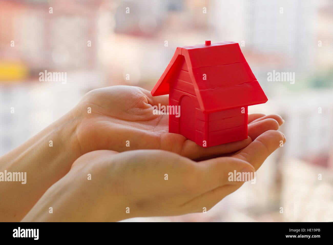 Kleine rote Haus in der Frauenhand Stockfoto