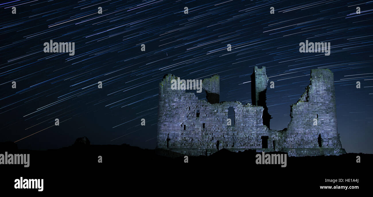 Ein nächtlicher Himmel voller Sterne am Dunstanburgh Castle in Northumberland, England Stockfoto