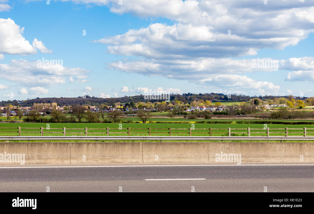 Dorf von Abridge in Essex, genommen von der anderen Seite der M11 mit einem schönen bewölkten und blauen Himmel. Stockfoto