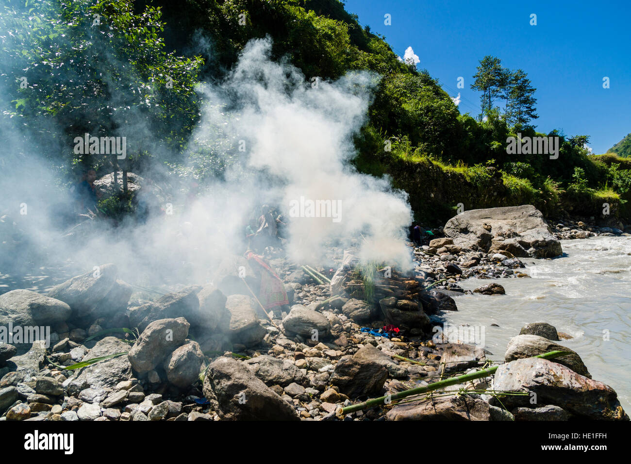 Das Feuer der Beerdigung eines Tod Körper bei der einäscherung Boden am Ufer des Flusses Kali Gandaki produziert eine Menge smok Stockfoto