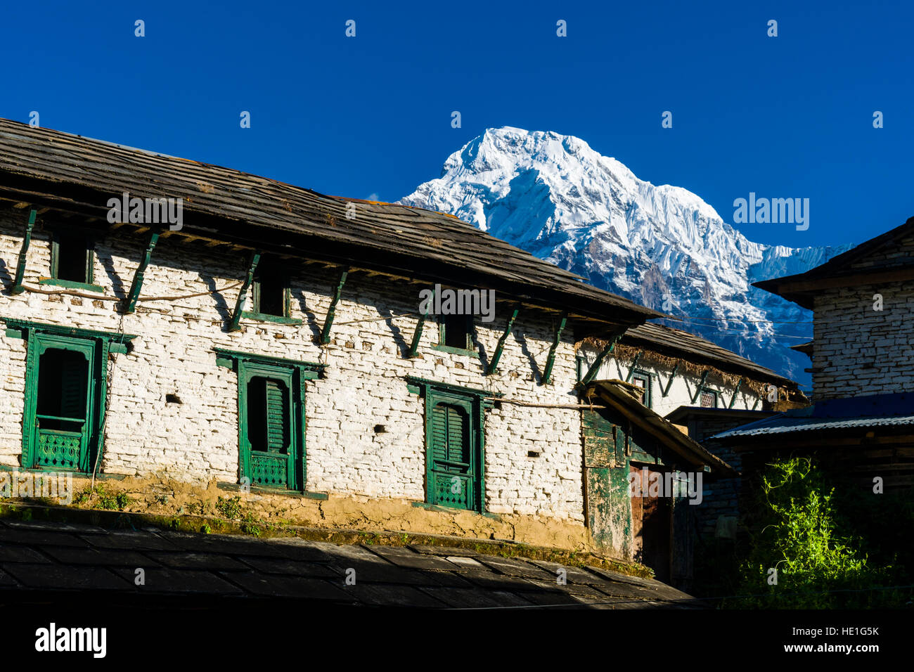 Ein Bauernhaus des historischen Dorfes mit der Berge Annapurna Süd in der Ferne Stockfoto