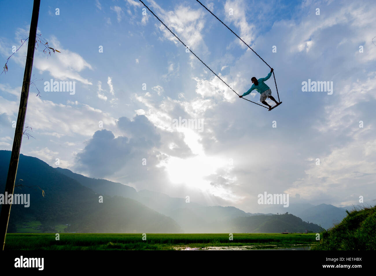 Kinder Schwingen auf einer großen Schaukel, für das Festival in darsain harpan Khola Tal errichtet. Stockfoto