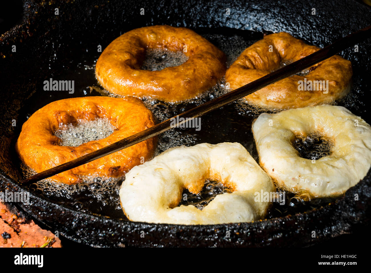 Donuts sind in einer Pfanne mit heißem Öl gebraten. Stockfoto