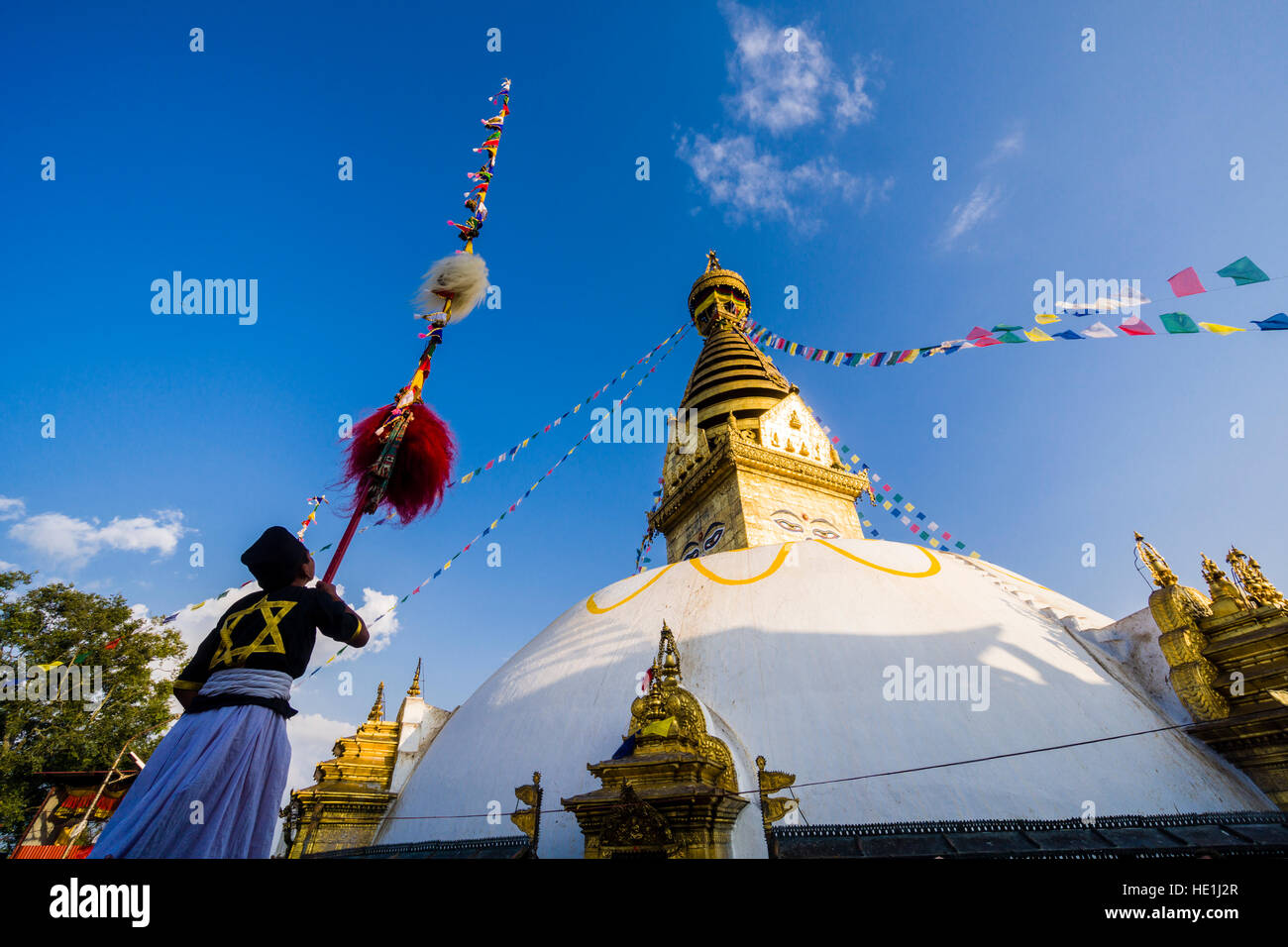 Ein Junge ist eine religiöse Leistung mit einem verzierten Pole an der weißen Stupa von swayambhunath Tempel, monkey Tempel Stockfoto