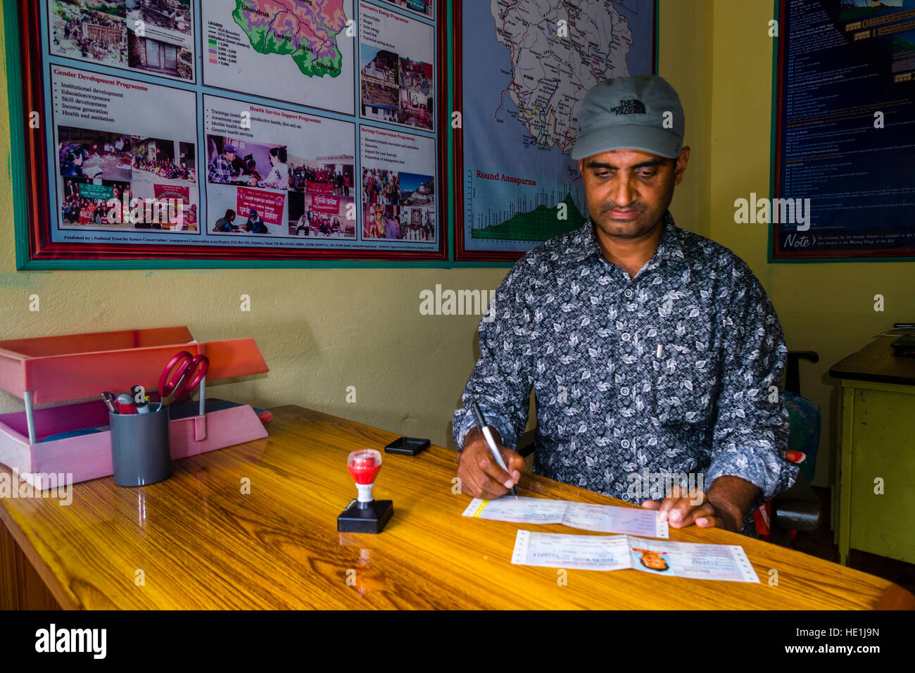 Ein Mitarbeiter des Nepal Tourism Board ist die Überprüfung der Genehmigung einer Trekker Stockfoto