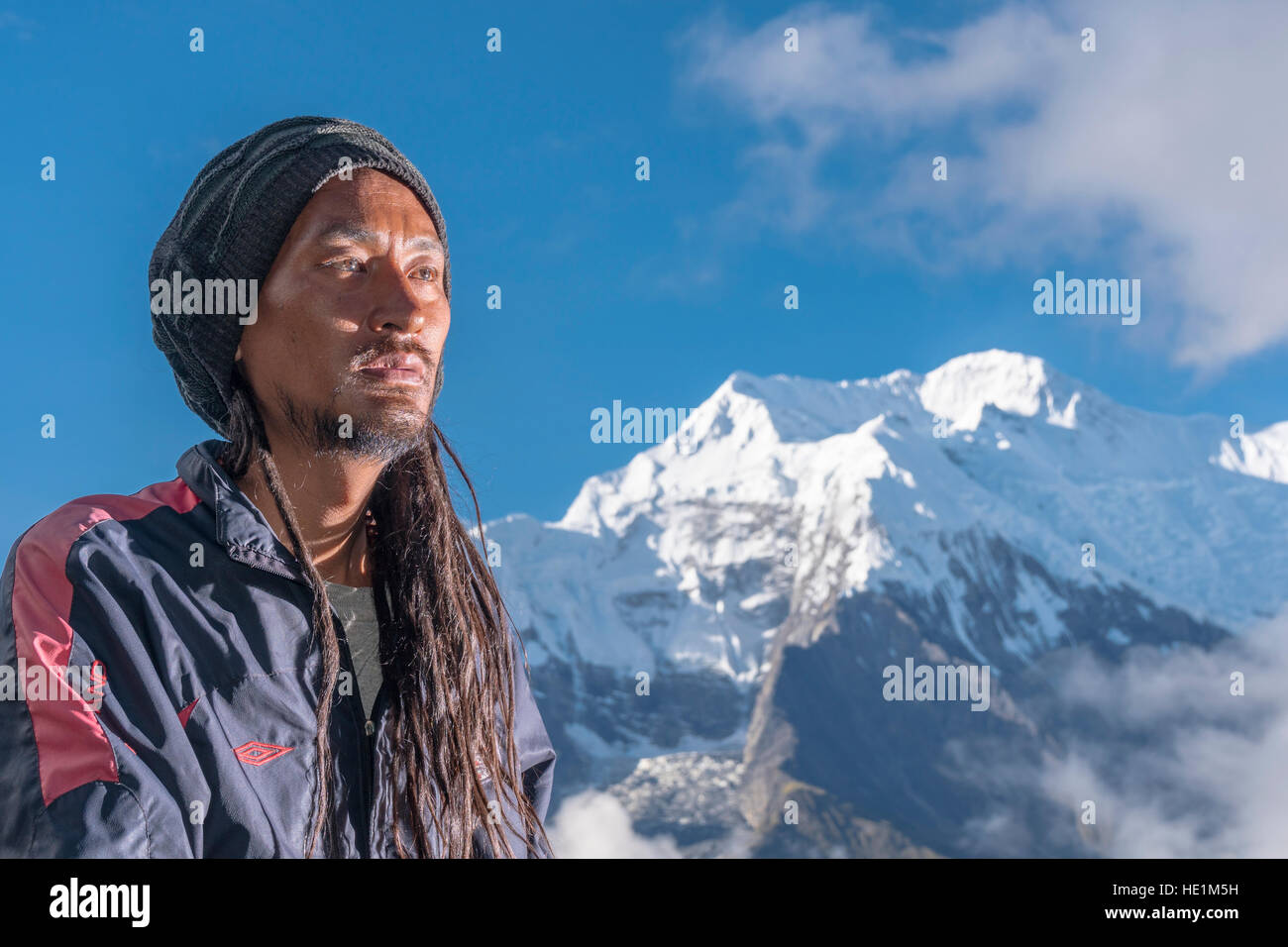 Ein Porträt eines jungen Mannes mit Dreadlocks, die Berge Annapurna 2 in der Ferne Stockfoto