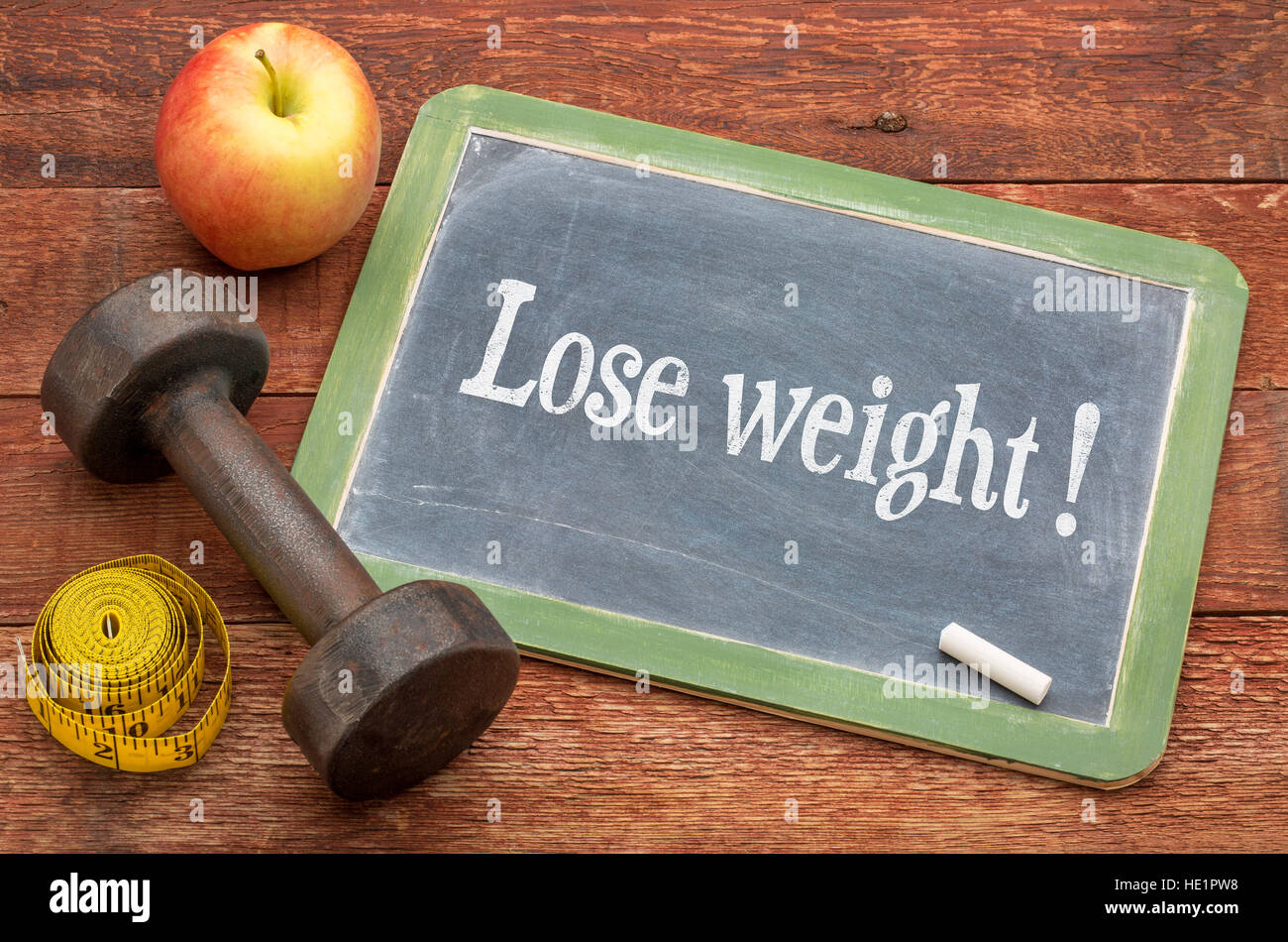 Verlieren Sie Gewicht Konzept - Schiefer Tafel Zeichen gegen verwitterte rot lackierten Scheune Holz mit einer Hantel, Apfel und Maßband Stockfoto