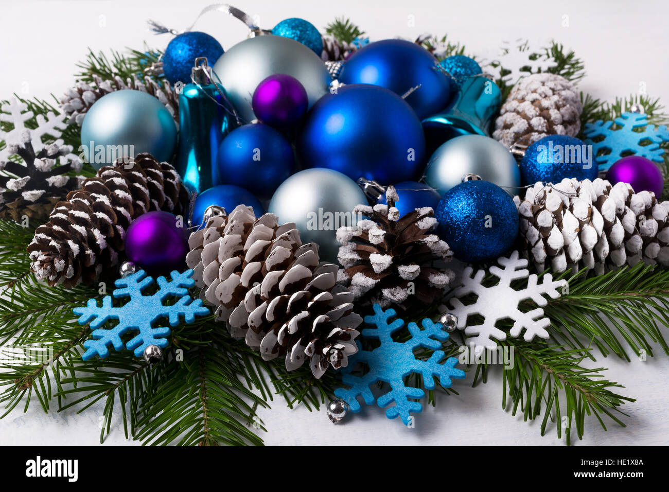 Weihnachts-Dekoration mit lila und blau schattiert Ornamente. Weihnachtsgruß Hintergrund mit blauen Kugeln, Tannenzweigen und Filz Schneeflocken. Stockfoto
