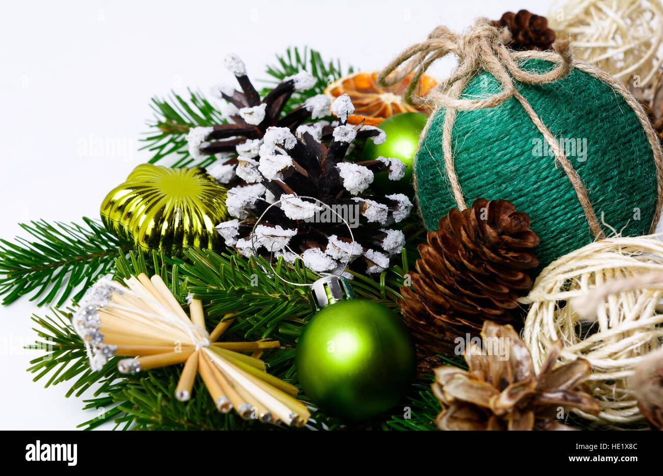 Handgemachte Weihnachtsdekorationen und verschneiten dekorierte Pinienzapfen. Weihnachts-Dekoration mit Tannenzweigen, getrocknete Orangenscheiben und rustikalen Kugeln. Stockfoto
