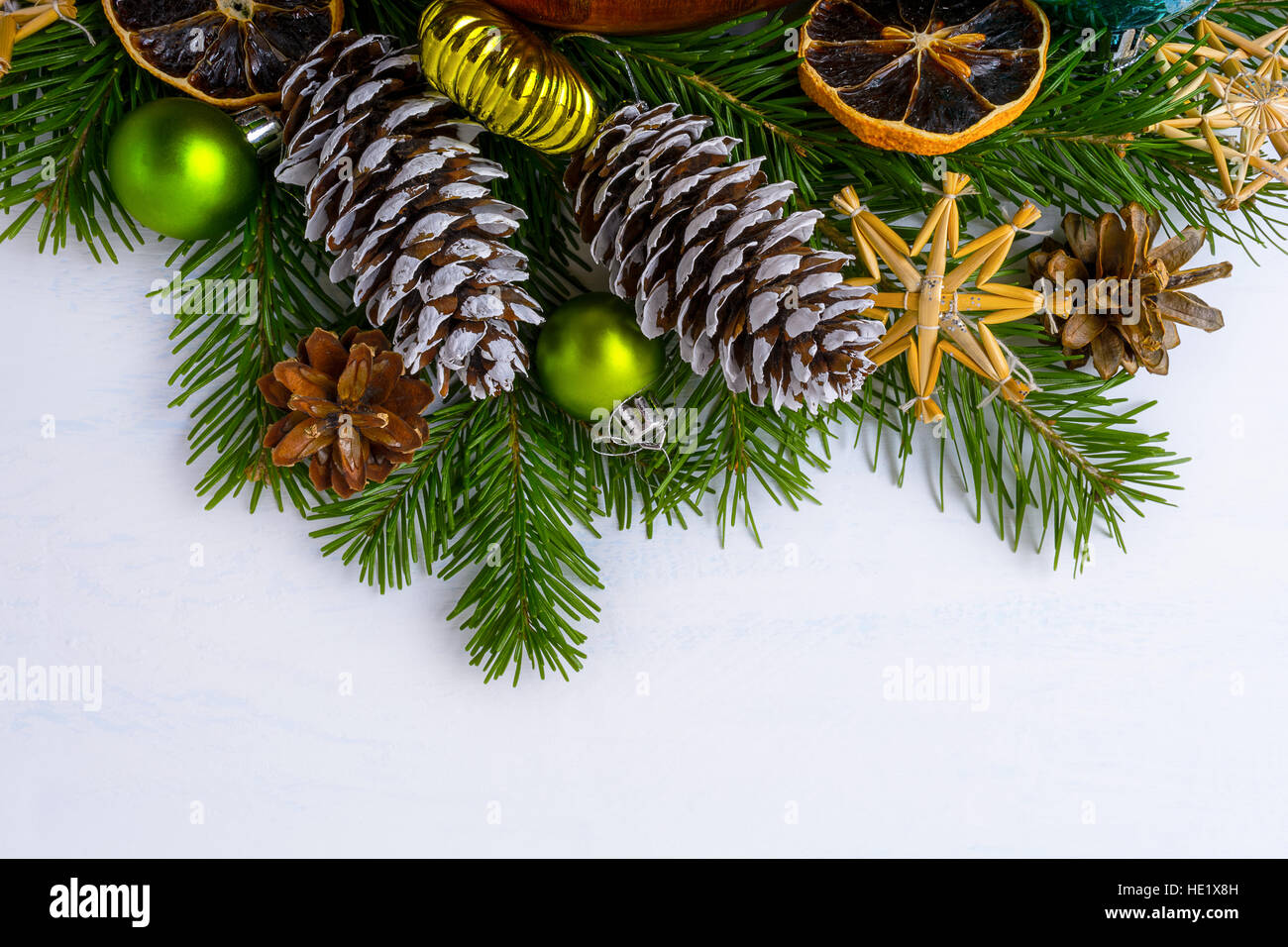 Weihnachtsbaum Äste, getrocknete Orangen und Tanne und Kiefer Kegel. Weihnachtsgruß Hintergrund mit grünen Kugeln und rustikale Ornamente. Kopieren Sie Raum. Stockfoto