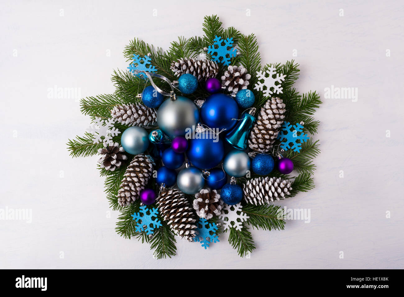 Weihnachtskranz blau schattiert Ornamente. Weihnachts-Dekoration mit blauen Kugeln, Tannenzweigen und Tannenzapfen. Weihnachten Gruß Hintergrund. Stockfoto