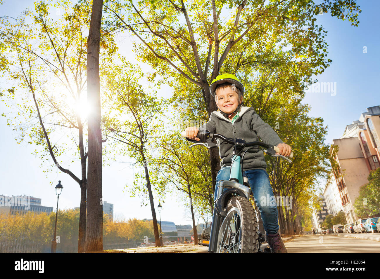 Porträt von fröhlicher Junge mit seinem Fahrrad am Stadtpark Stockfoto